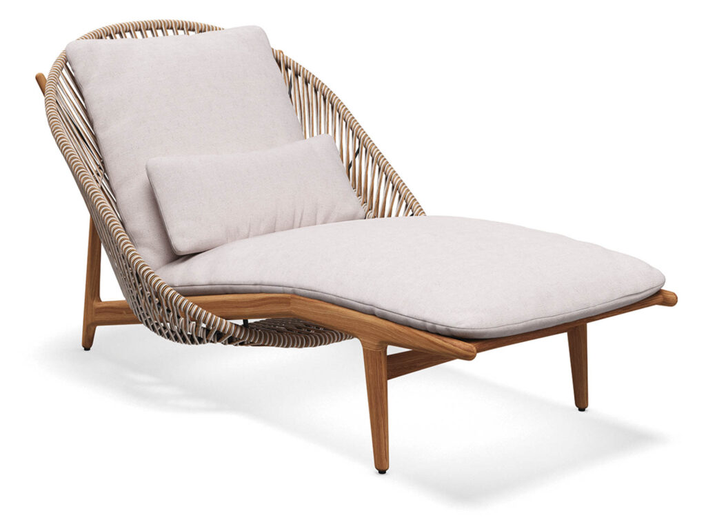 a wicker lounge chair with white cushion