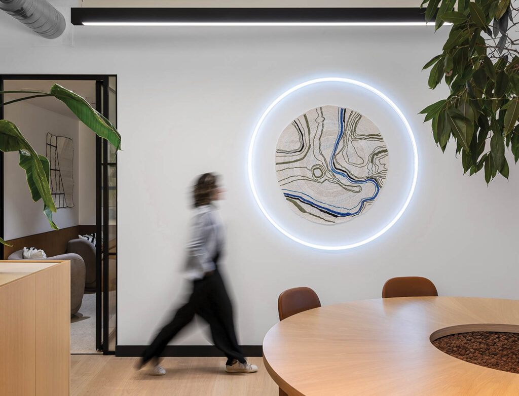 person walking near wall with circular led light around a textile