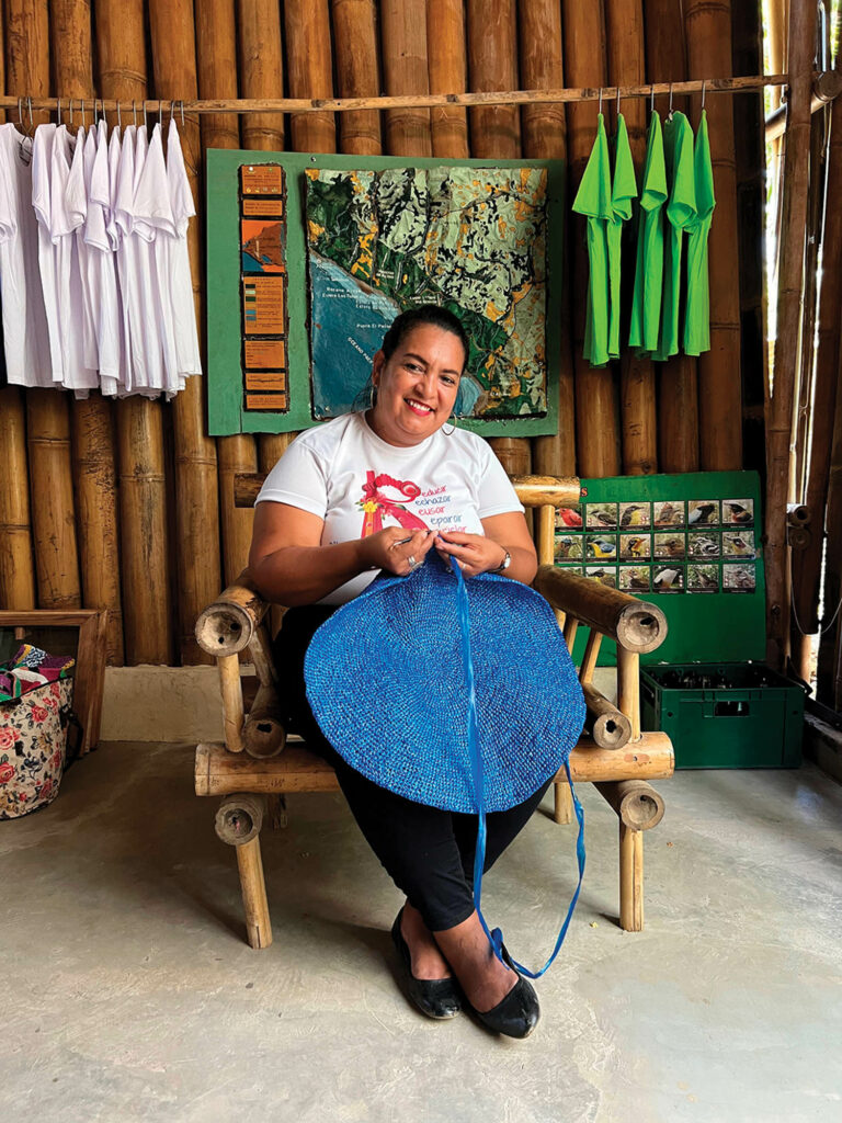 artist weaving a blue textile circle