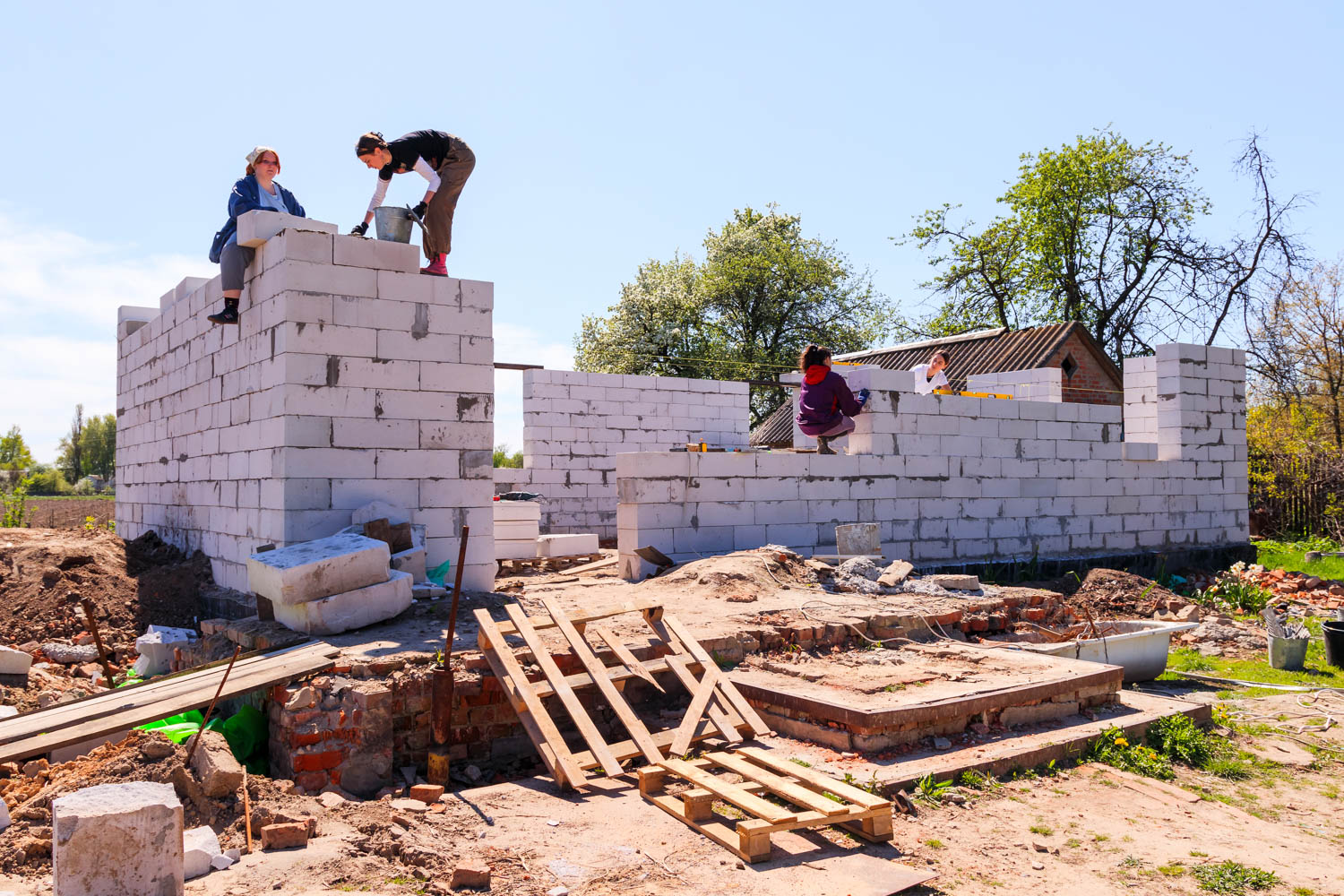 people working on putting bricks together at a construction site