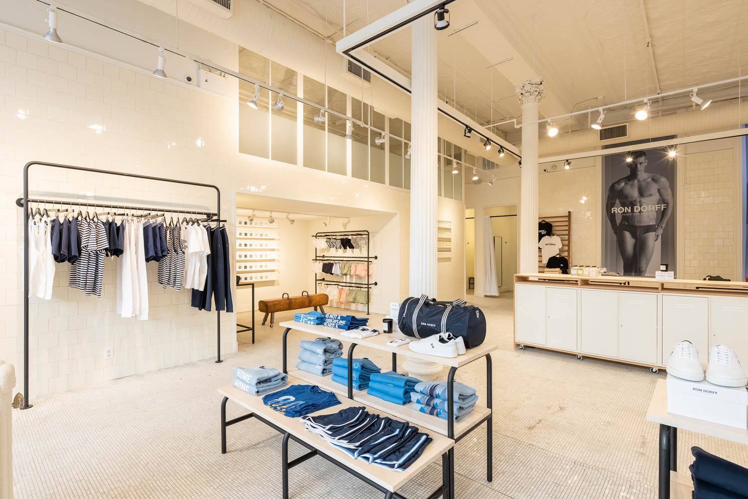 Ron Dorff storefront with bright lights and clothes folded on shelves