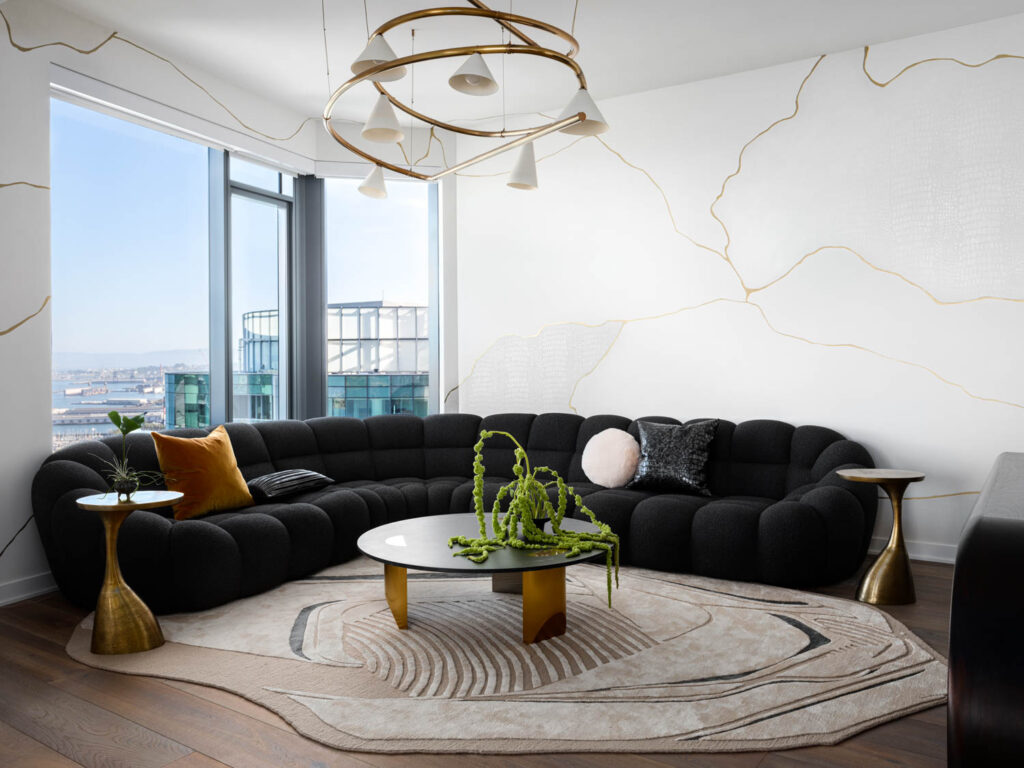 living room with curved black couch, marble walls and city views