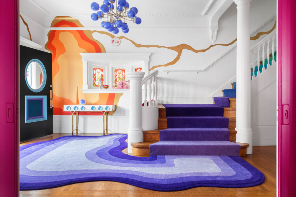 entryway of house with purple carpet and runner and colorful accents on the wall