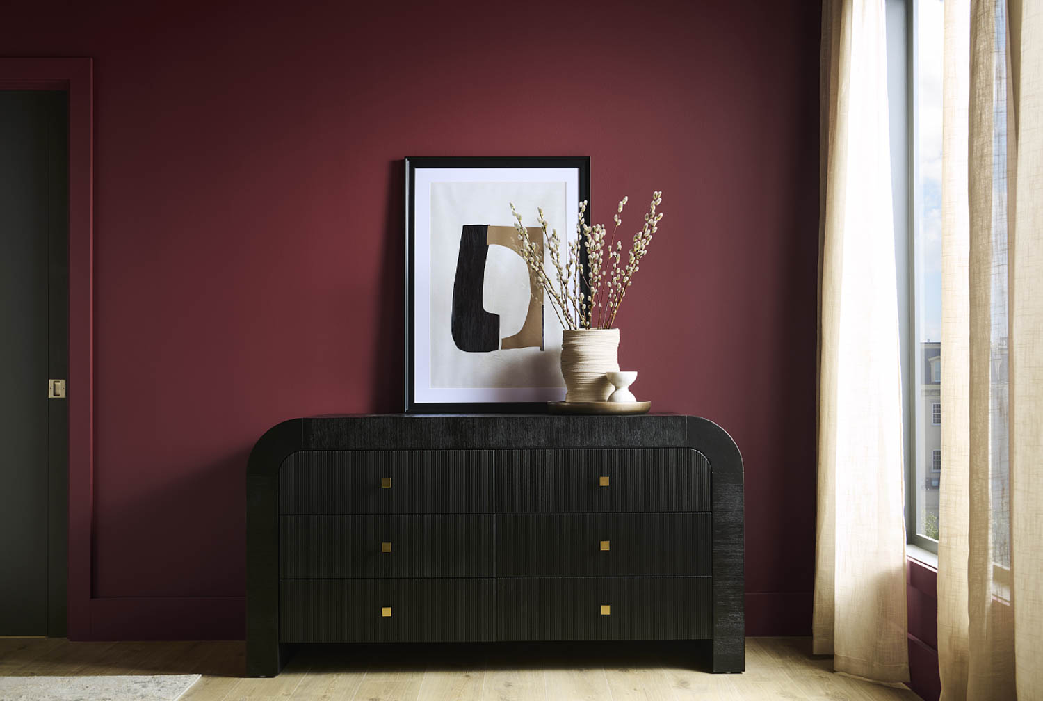 bedroom with dark red walls and black drawer