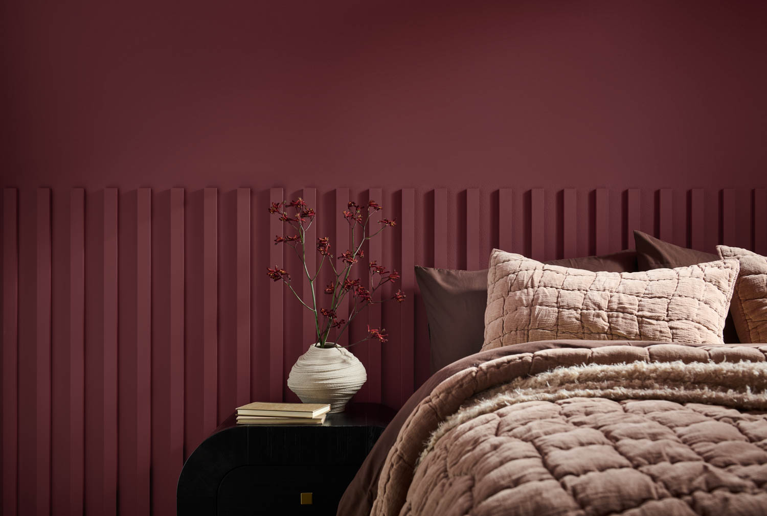 bedroom with dark red walls and tan sheets