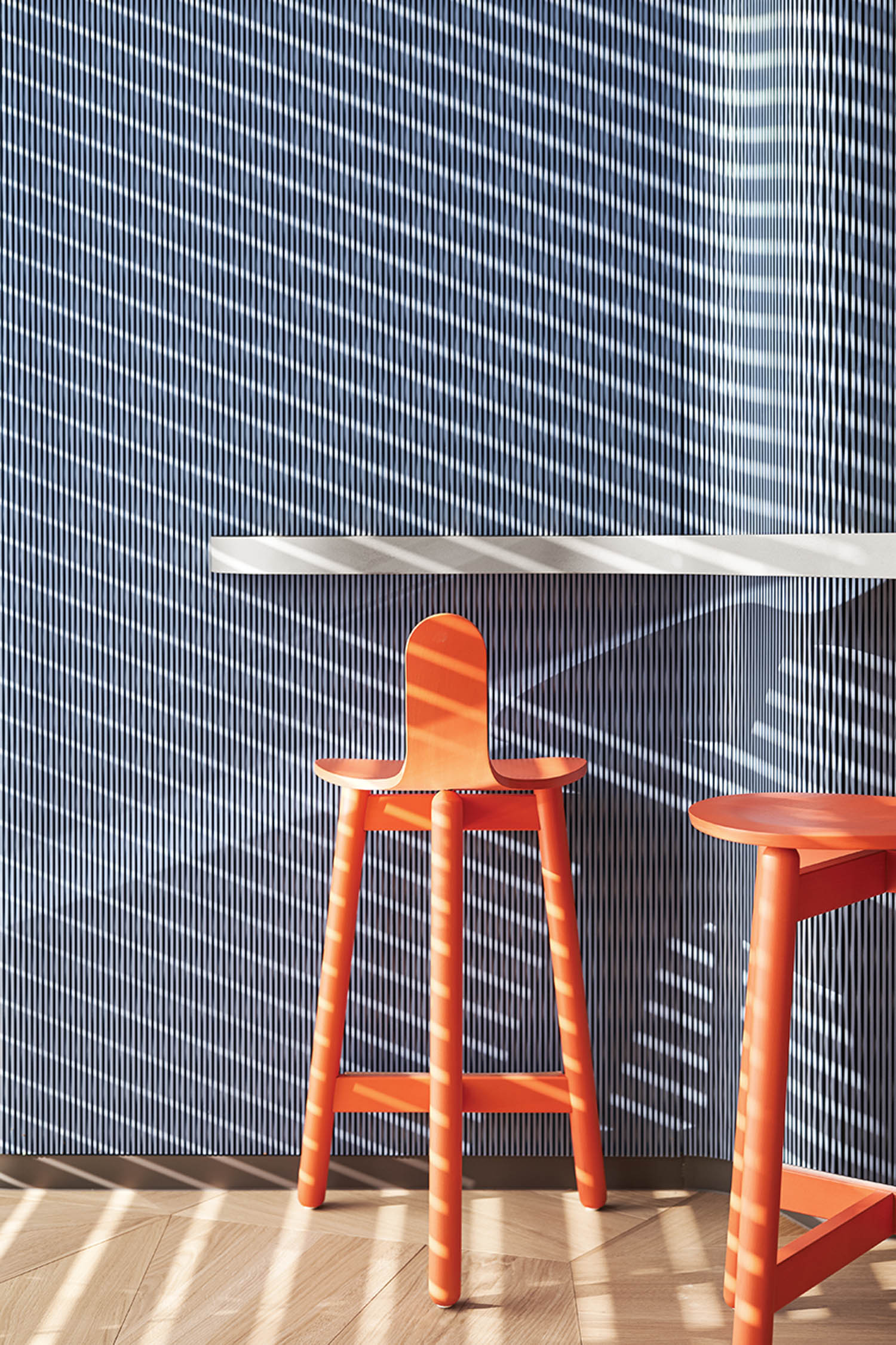 orange bar stools against a blue background