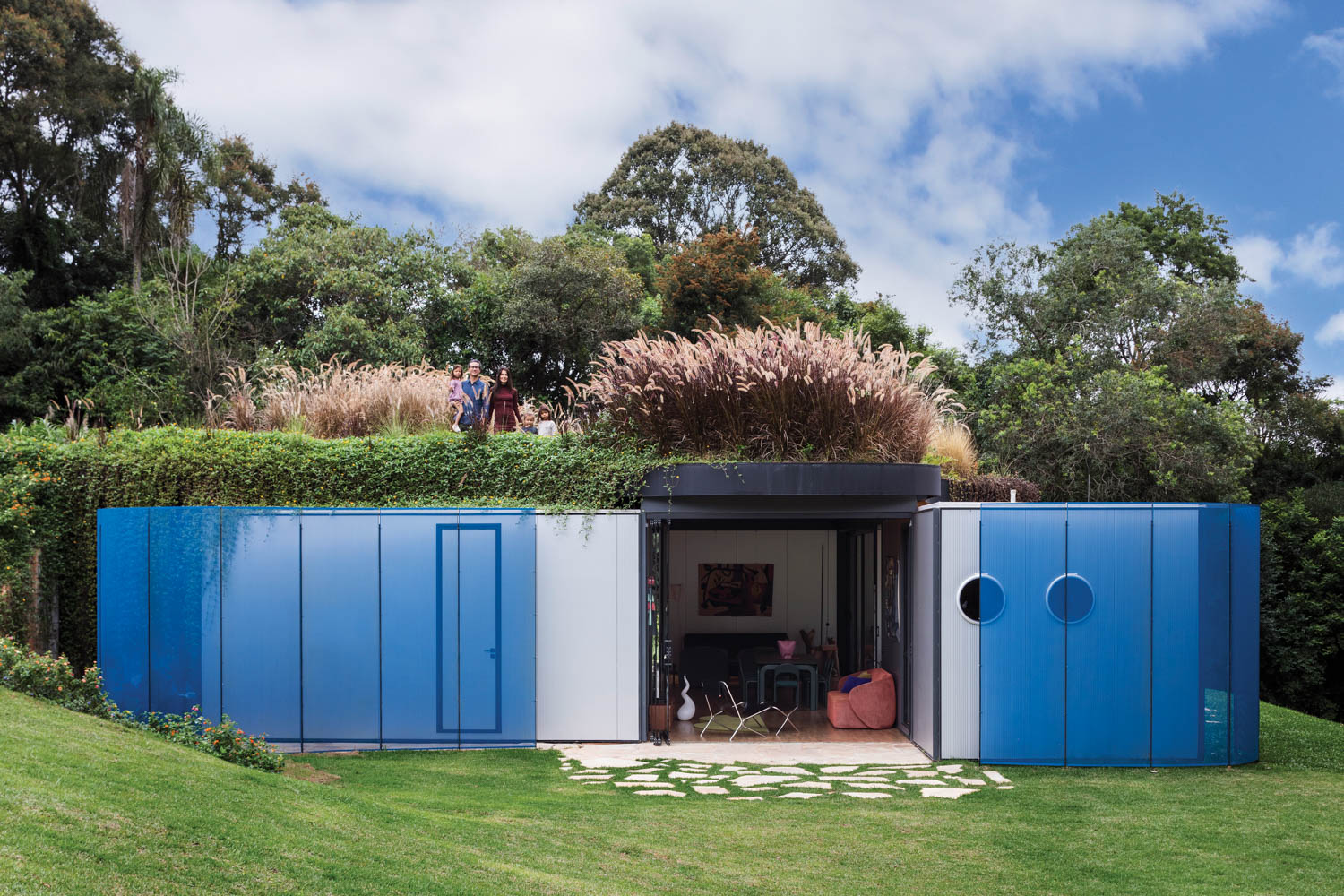 front of home with blue panels over the sliding doors and a planter on top of the modules