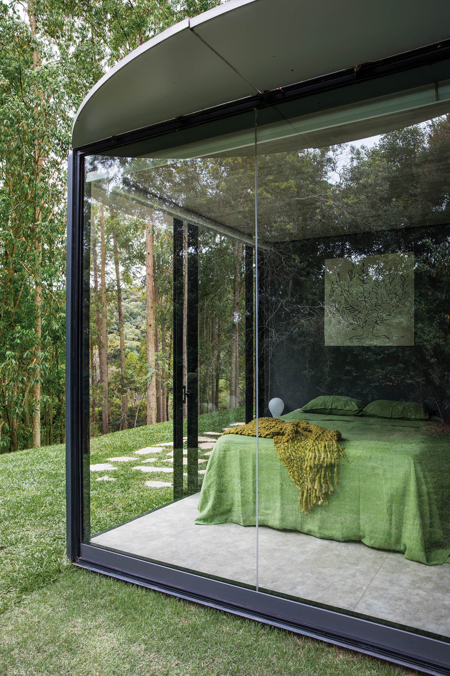 main bedroom with glass-wall module and green sheets