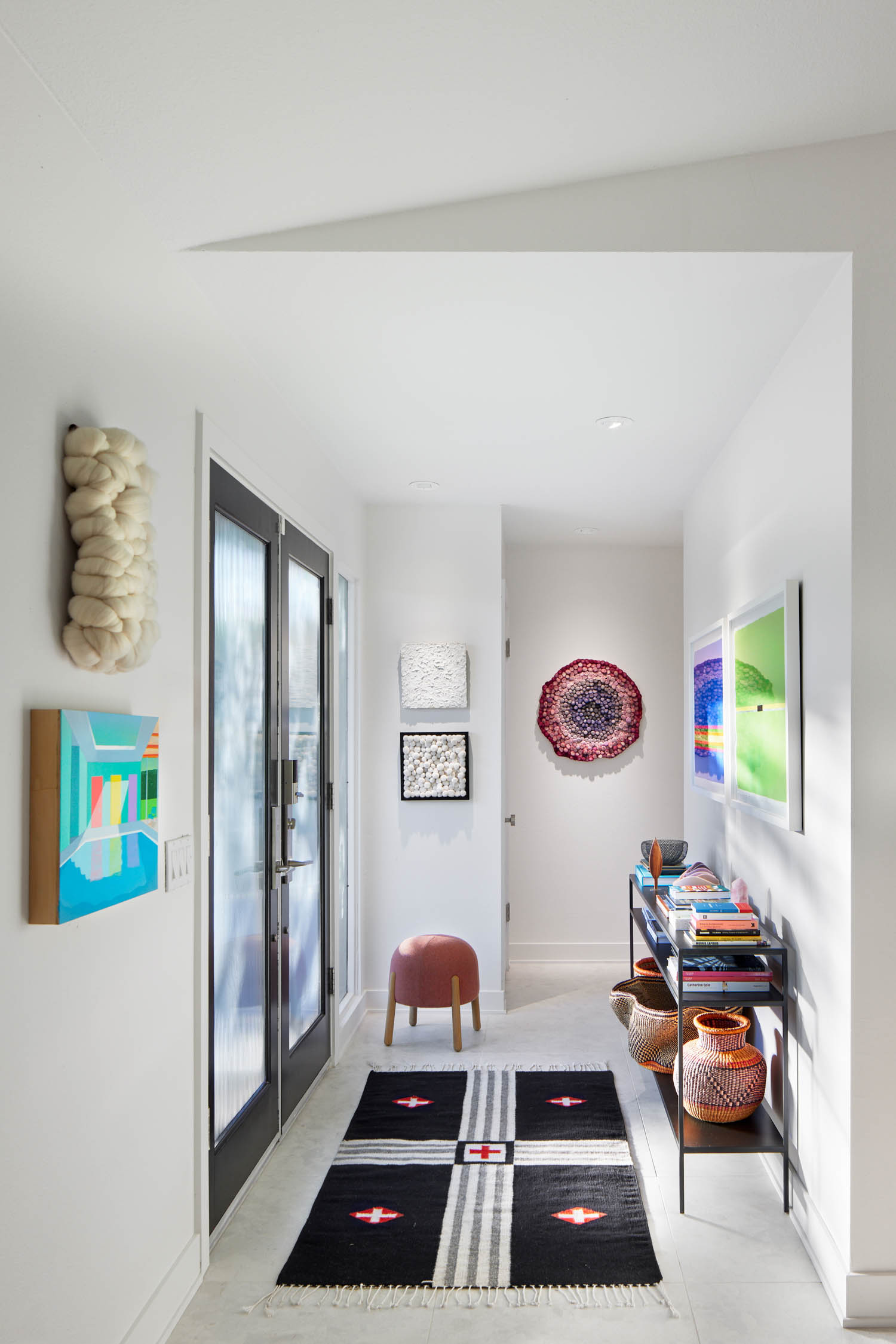 entrance area with black rug and lots of artwork