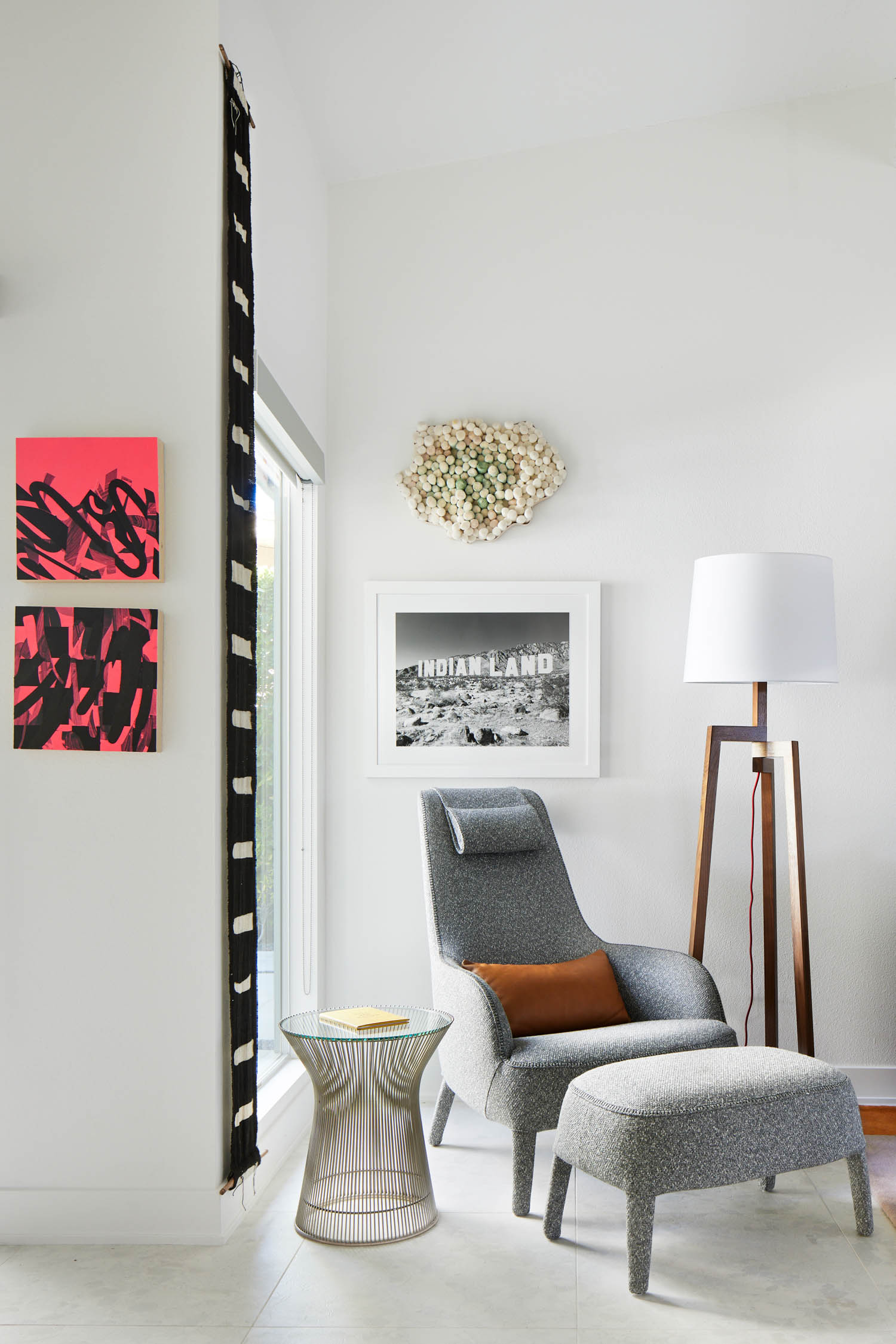 reading nook with grey armchair, artwork and mesh table