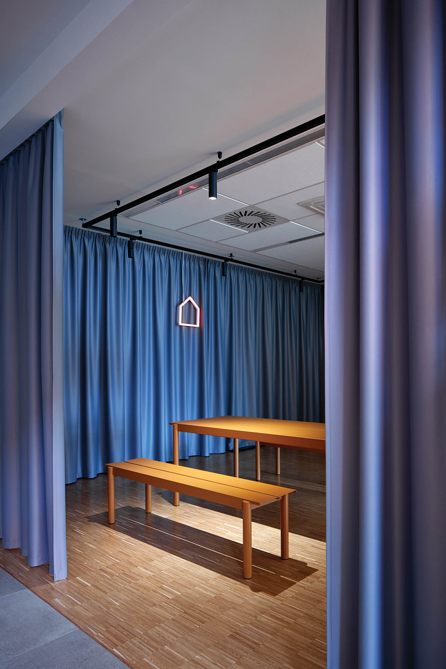 seating area with benches, tables and blue drapes