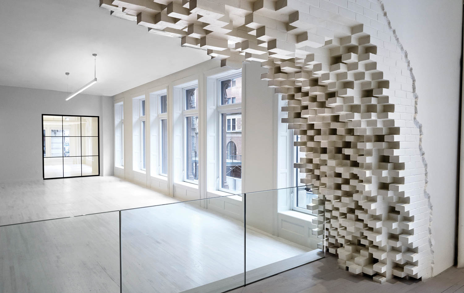 all-white entry way with exploding brick wall sculpture