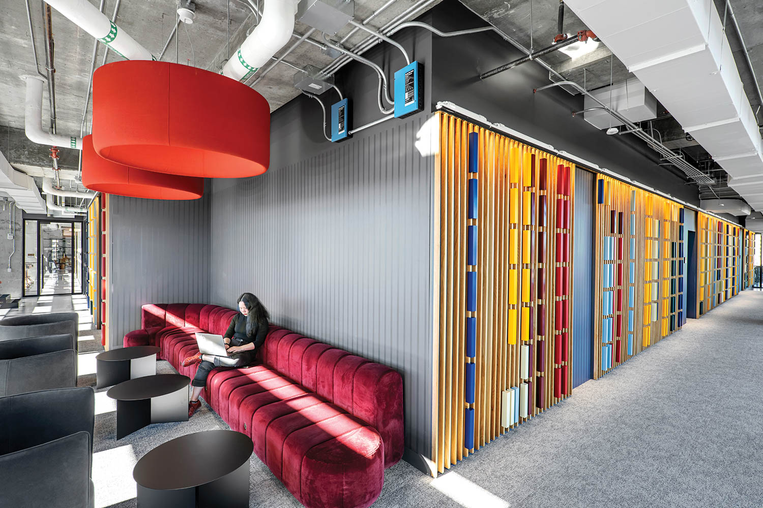 seating area with magenta couch and colorful doors nearby