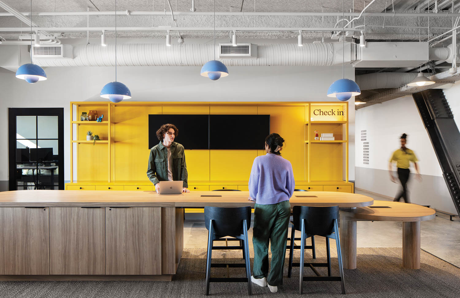 yellow break room area with long tv and desk