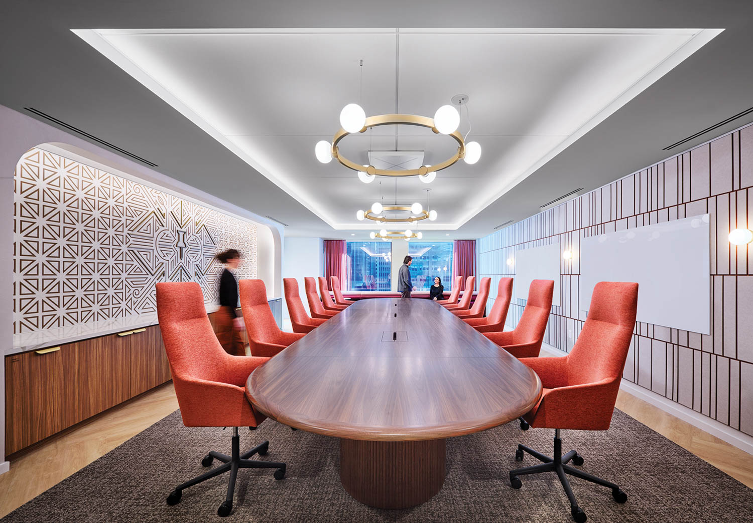 conference room with long table, bright chandelier and red chairs