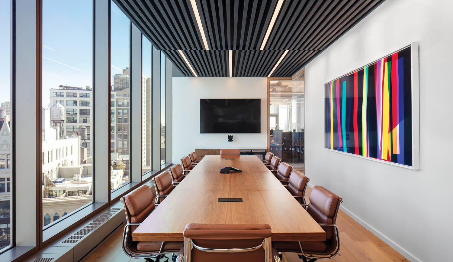 conference room with colorful artwork, long table and windows