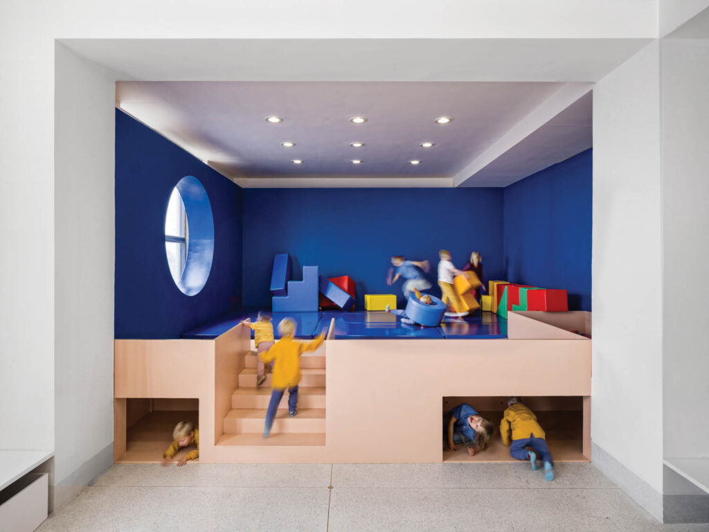 playground area for kids with dark blue walls, fabric padded mats and building blocks