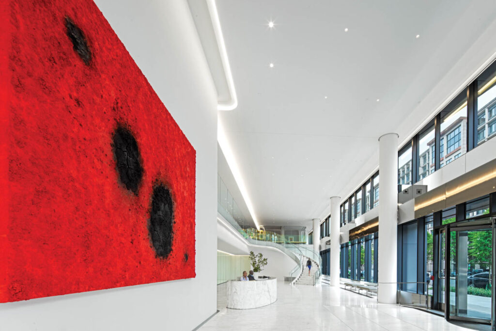 lobby with red artwork, staircase and marble reception area