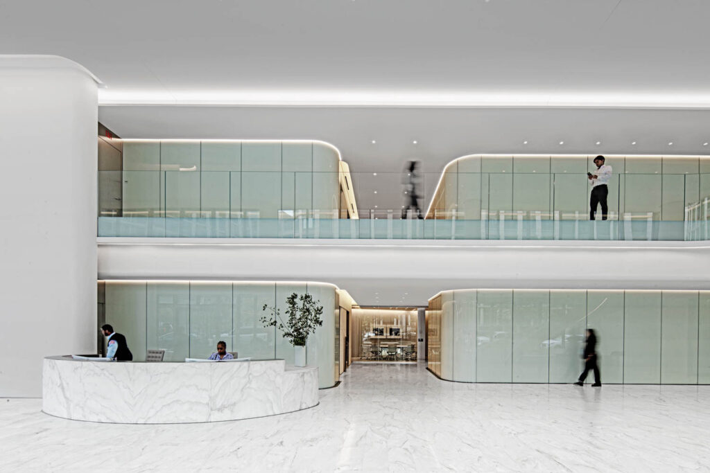 lobby with illuminated curved glass walls and reception stand