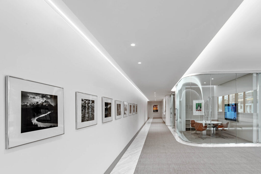 gallery wall facing a meeting room with curved glass walls