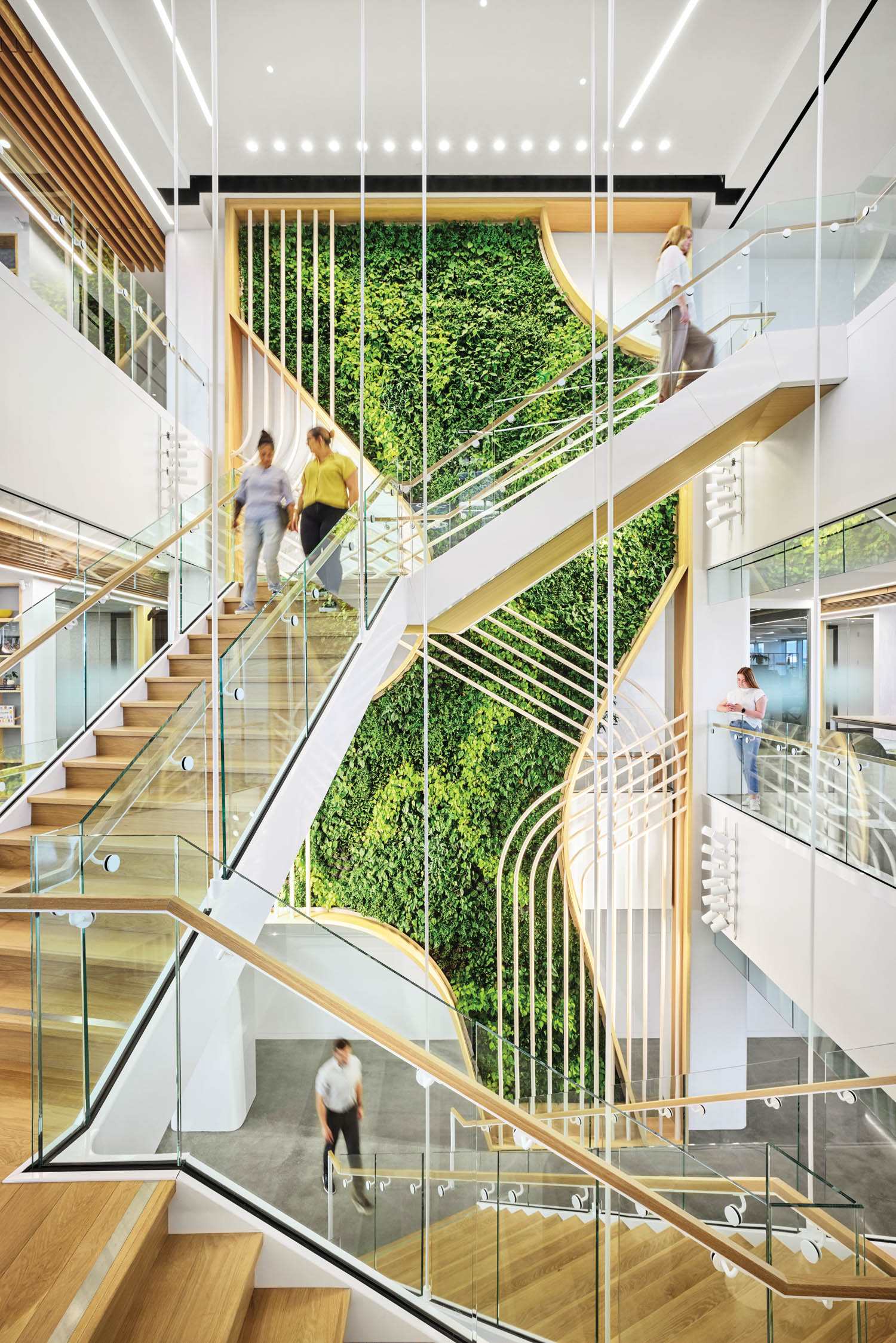 atrium stairway with tall living wall full of plants that covers over four stories