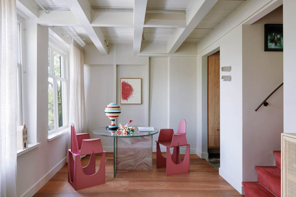 room with geometric pink chairs and beamed ceilings