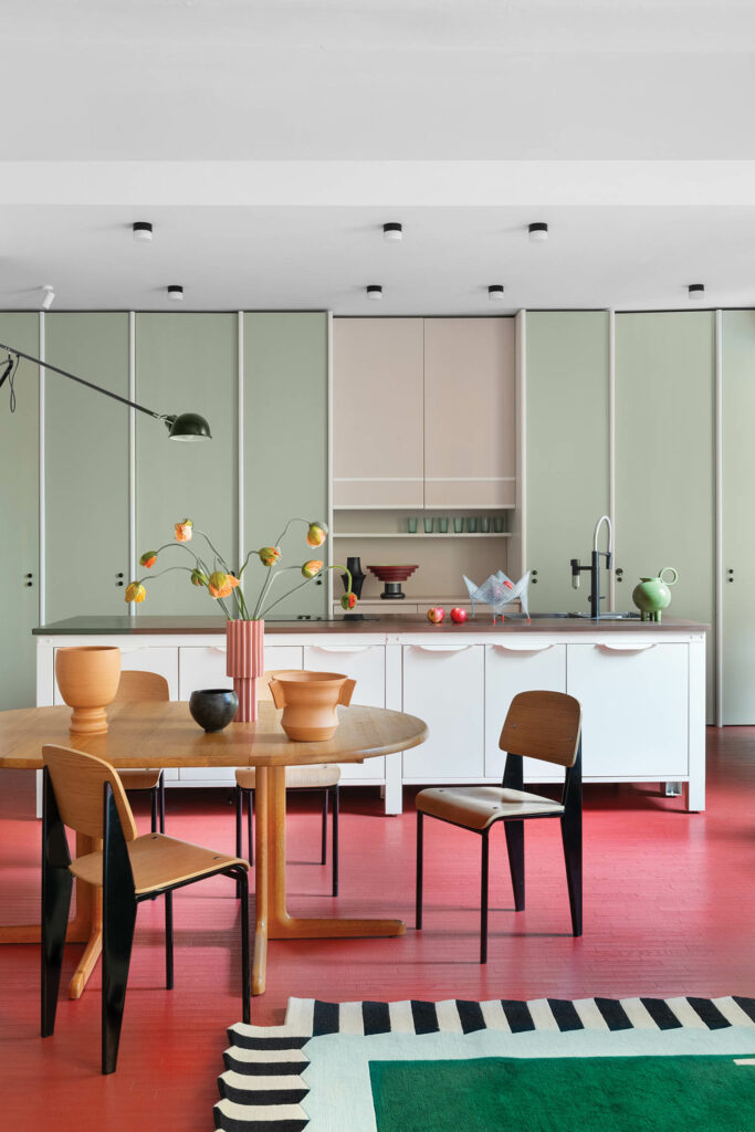 the home kitchen with a red floor and green cabinets