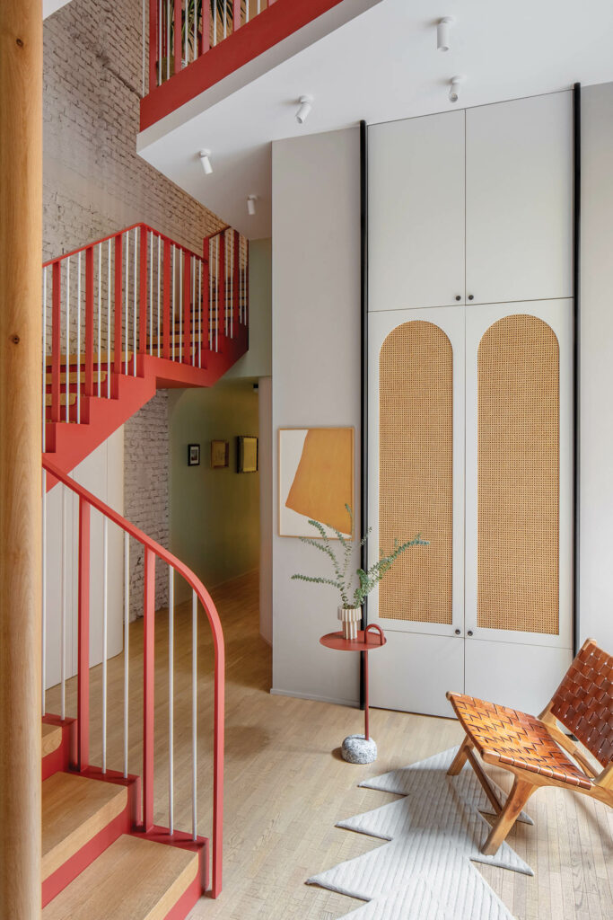 the entry features built-in cabinets and a winding red stair