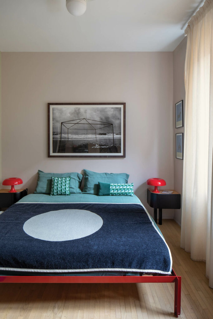 a bedroom with a deep blue bed cover and teal pillows