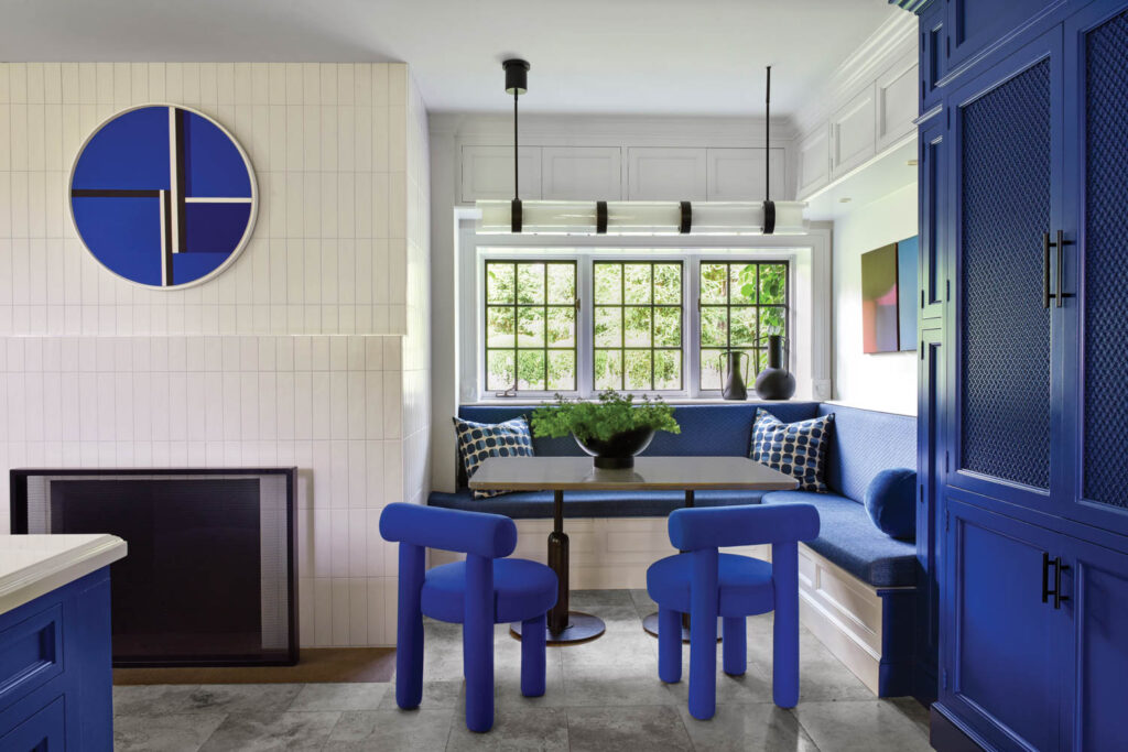 the kitchen includes a blue bench and blue chairs