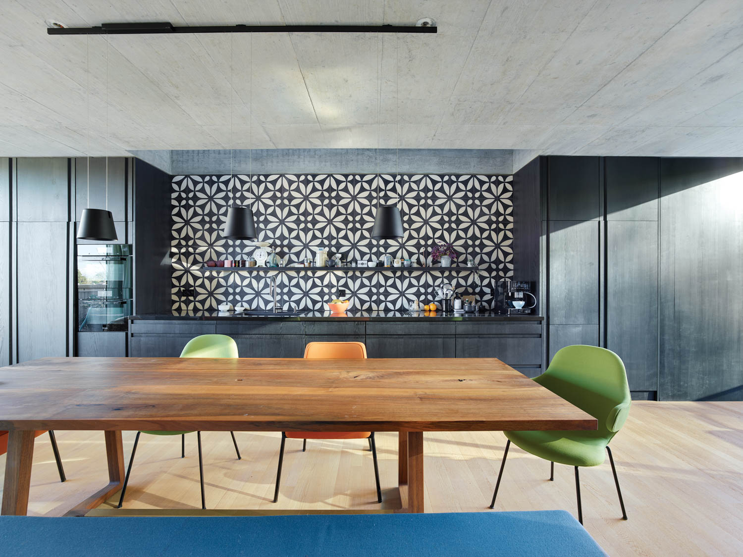 dining area with long wooden table and bar with dark cabinets