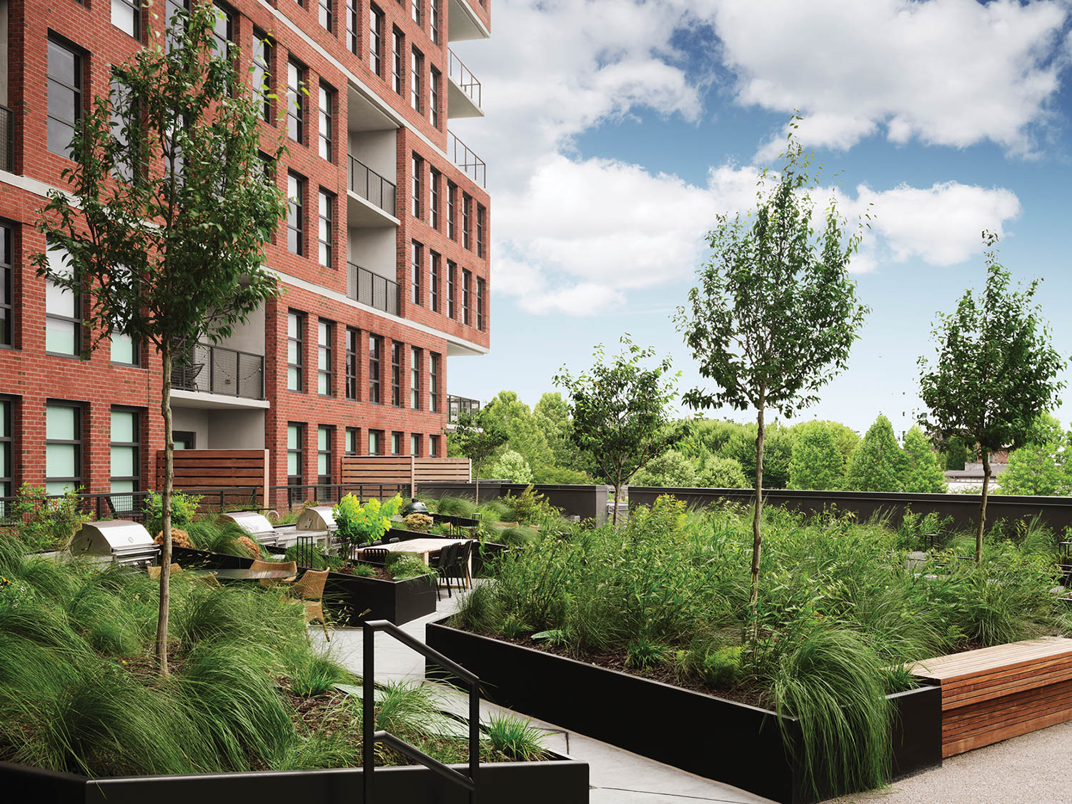 exterior of redbrick rental building surrounding by nearby greenery