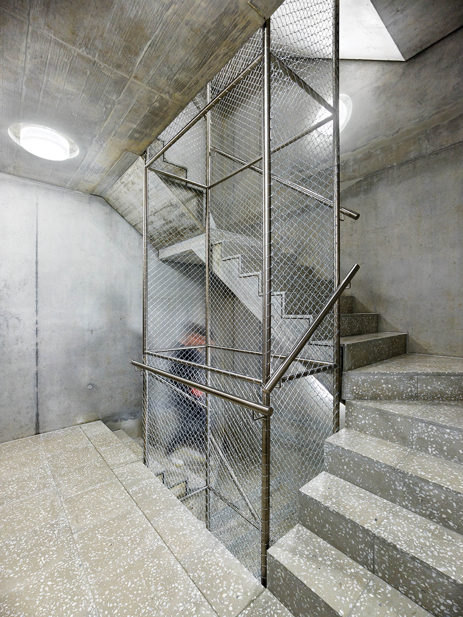 stairwell with concrete stairs and skylights