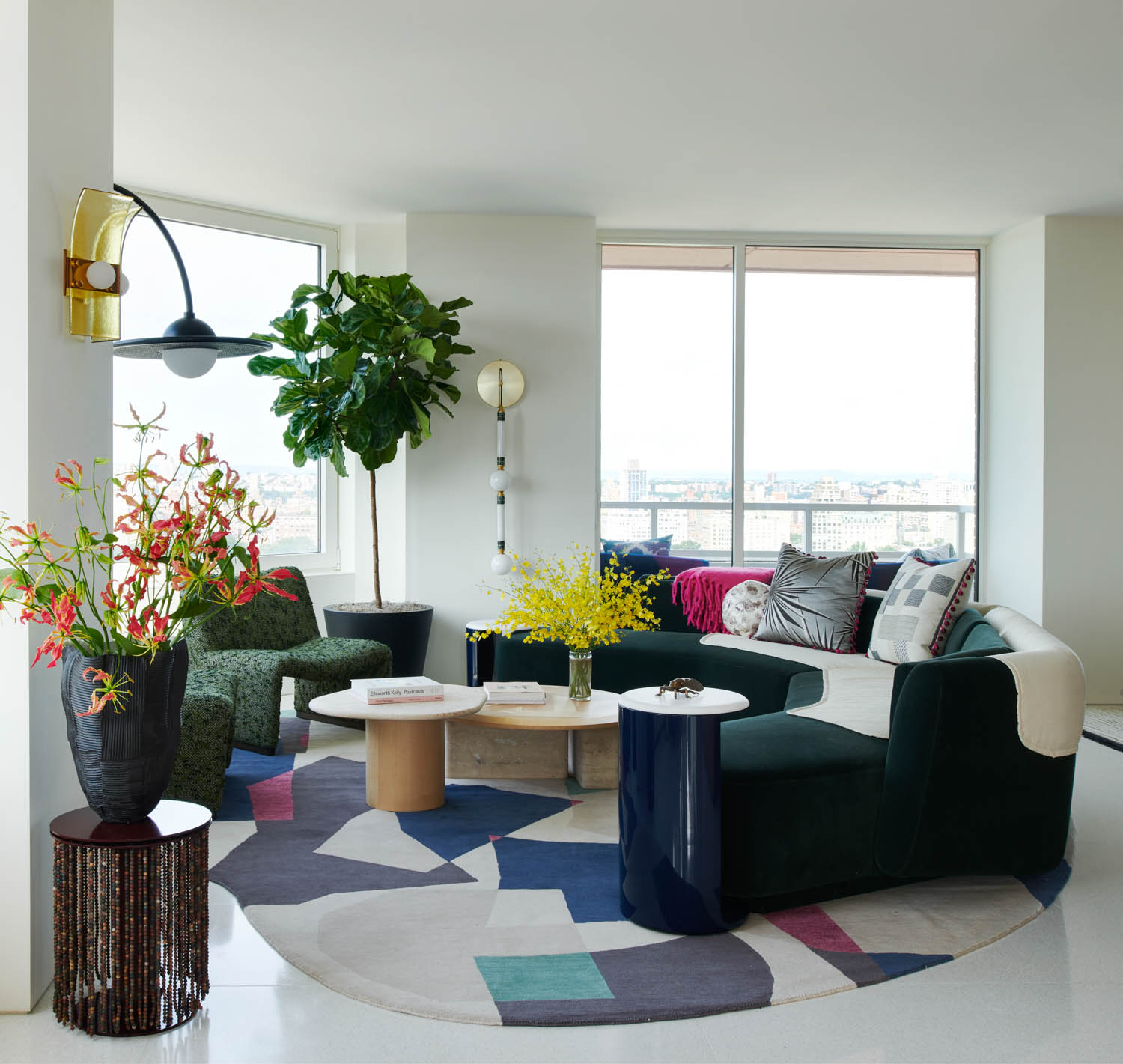 living room with sconces, curved chair and hanging plant